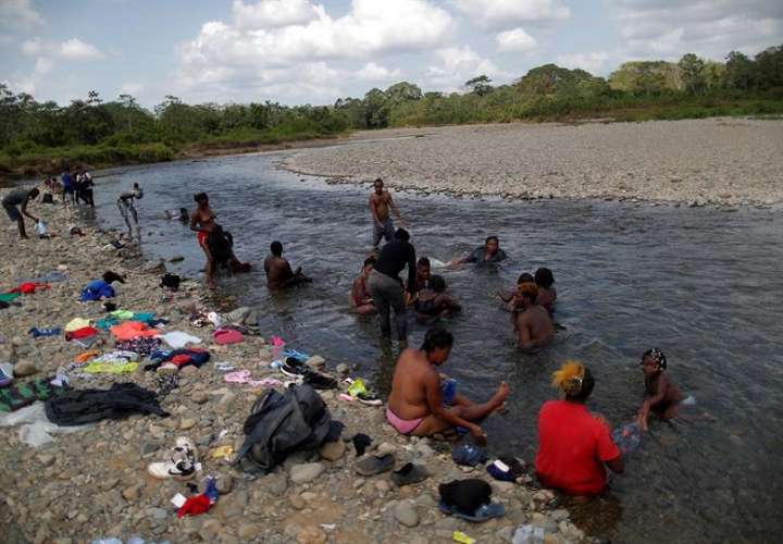 Migrantes haitianos se bañan en el río Tuquesa, en la comunidad de Bajo Chiquito, en Darién (Panamá). EFE/