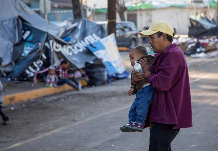 Migrantes permanecen hoy a la intemperie fuera del albergue original que resultó inhabitable luego de las fuertes lluvias en Tijuana (México). EFE