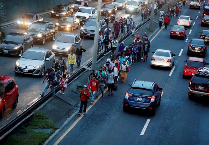 Migrantes hondureños caminan entre el tráfico hacia el departamento de Escuintla para acercarse a la frontera con México hoy, jueves 18 de octubre de 2018, saliendo del albergue Casa del Migrante en Ciudad de Guatemala (Guatemala). EFE