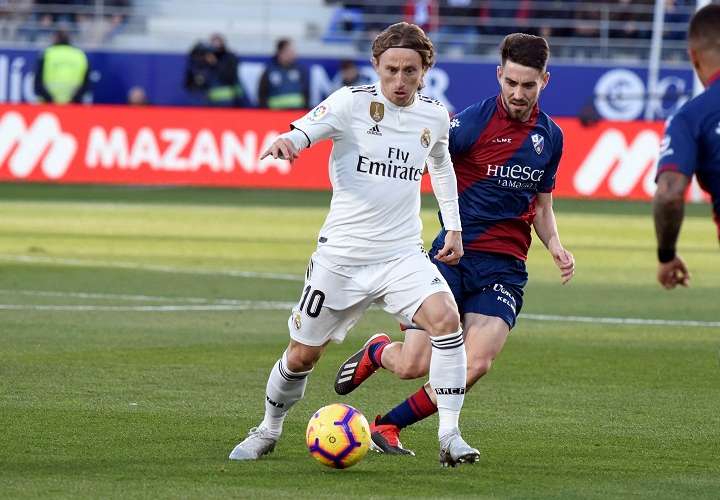 El delantero croata del Real Madrid Luka Modric (i) y el cenrocampista del Huesca Moisés Gómez. Foto: EFE