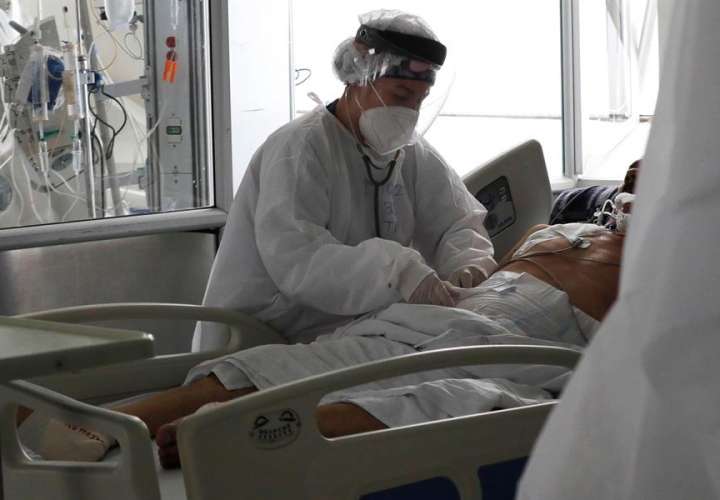 Una empleada de la salud atiende a un paciente en una unidad de cuidados intensivos para enfermos de covid-19 en el Hospital El Tunal en Bogotá (Colombia). EFE