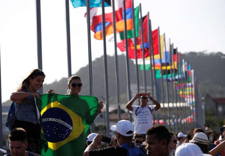 Peregrinas brasileñas se toman una fotografía frente a la bahía de Panamá, junto a las banderas de los países que participarán en la Jornada Mundial de la Juventud (JMJ) el lunes 21 de enero de 2019, en Ciudad de Panamá. EFE