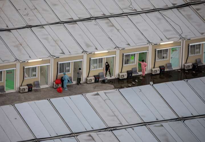 Personas aisladas frente a sus cabañas en la instalación de aislamiento comunitario de Tsing Yi en Hong Kong. EFE