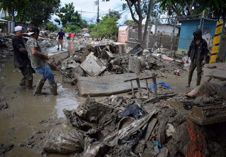 Personas retornan hoy a sus viviendas para retirar los escombros tras las inundaciones que dejó a su paso Iota, en la localidad de La Lima, departamento de Cortés (Honduras). EFE
