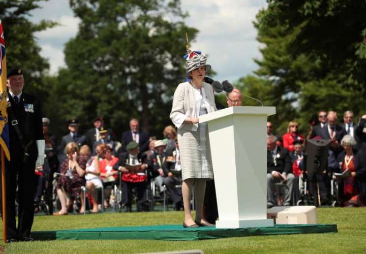La primera ministra británica, Theresa May, en un momento del discurso que pronunció este jueves en una ceremonia en el Cementerio de la Commonwealth con motivo de las celebraciones del 75º aniversario del desembarco de Normandía. EFE