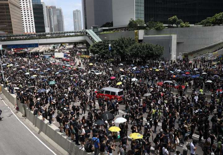 Manifestantes bloquean una calle principal fuera de los edificios gubernamentales en Hong Kong, China, 21 de junio de 2019. EFE