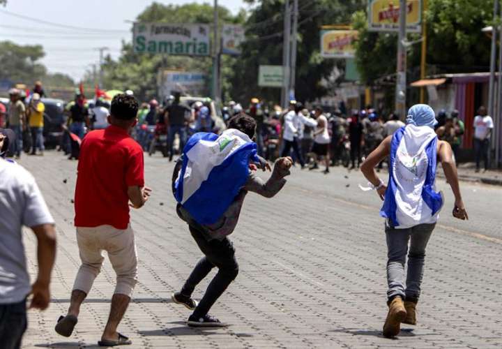 Varios jóvenes se enfrentan a las fuerzas de choque del Gobierno durante la marcha 