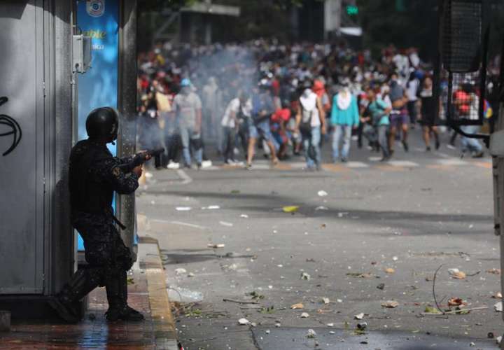 La Policía Nacional Bolivariana se enfrenta a manifestantes durante una protesta contra el presidente de Venezuela, Nicolás Maduro, este miércoles en Caracas (Venezuela). EFE