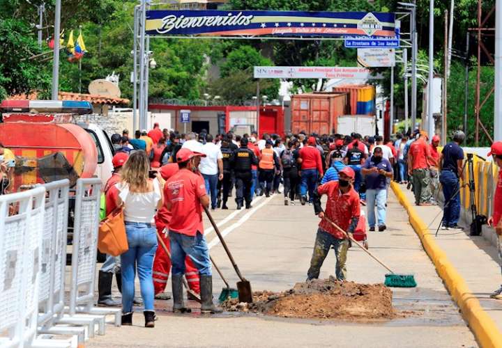 Trabajadores limpian tras el desmonte de un contenedor que impide el paso fronterizo entre Colombia y Venezuela, luego del anuncio de reapertura hoy. EFE