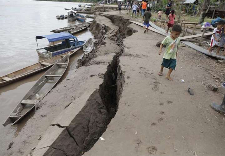 Un niño camina cerca de una grieta en el suelo, causada por un terremoto de magnitud 7,5 en la escala de Richter este domingo, en Puerto Santa Gema, en la ciudad amazónica de Yurimaguas (Perú). EFE