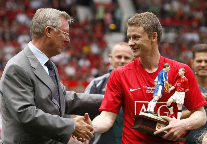 El noruego Ole Gunnar Solskjaer (rojo) estrecha la mano de su extécnico en el Manchester United, Sir Alex Ferguson. /AP