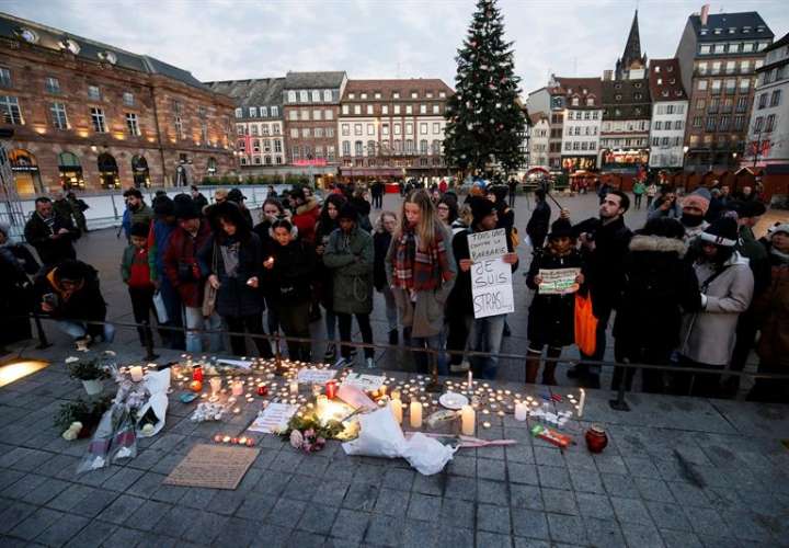 Ciudadanos encienden velas y escriben mensajes hoy, 12 de diciembre de 2018, en el lugar donde falleció una de las víctimas en el atentado en Estrasburgo (Francia). EFE