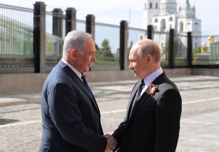 El presidente ruso, Vladimir Putin (d), estrecha la mano del primer ministro israelí, Benjamin Netanyahu (i), antes de las celebraciones del Día de la Victoria en Moscú (Rusia) hoy, 9 de mayo de 2018.  EFE