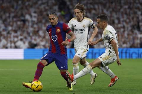 Lucas Vázquez (dcha) y Luka Modric (c) pelean por el balón con Raphinha./ EFE