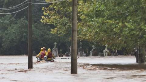 Miembros de instituciones de rescate buscando personas entre las inundaciones que han dejado las lluvias. EFE