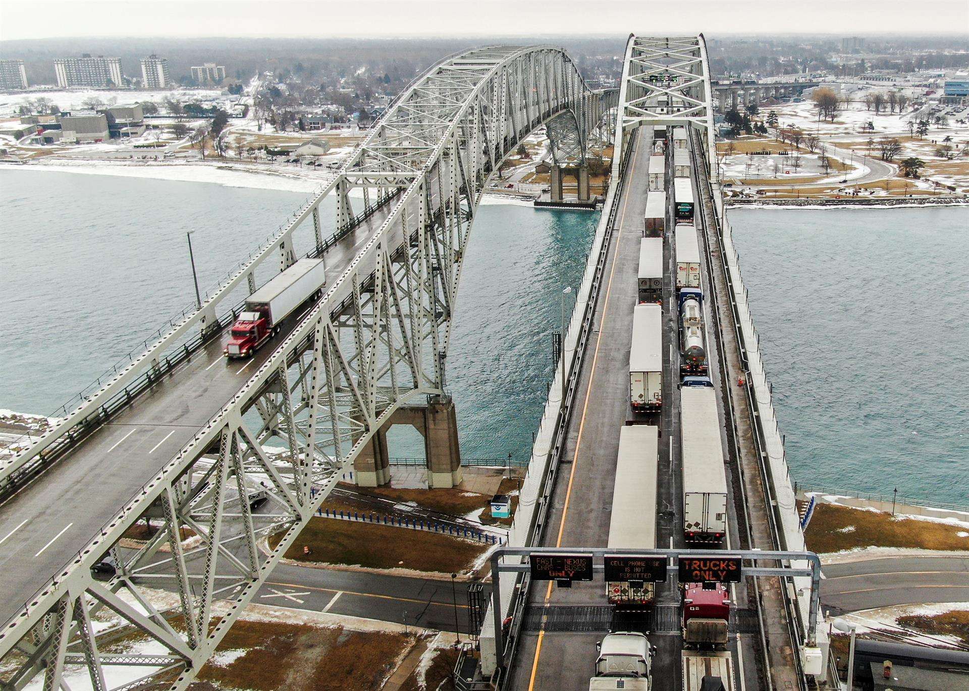 Una foto aérea hecha con un dron muestra camiones (d) que entran en Canadá respaldados en el Puente de Agua Azul sobre el río St. Clair que une los Estados Unidos y Canadá.