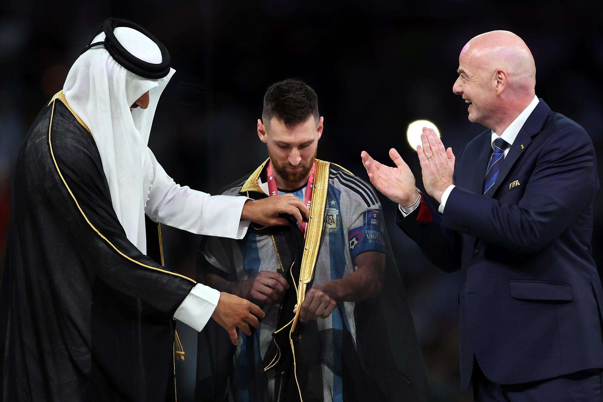 El emir  Tamim bin Hamad Al Thani (L) coloca el &quot;bisht&quot; a Messi. /EFE