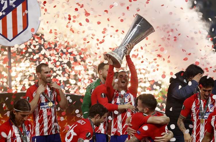 Antoine Griezmann (c) de Atlético Madrid sostiene el trofeo junto a sus compañeros hoy. Foto: EFE