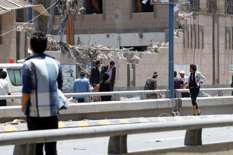 Varios yemeníes inspeccionan la escena tras un bombardeo de la coalición árabe contra la sede de la presidencia yemení en Saná, este 7 de mayo. EFE