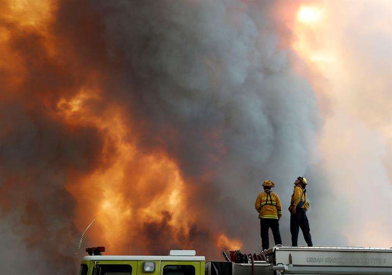 Un par de bomberos fue registrado al observar la ladera de una colina en llamas en Lakeport (California, EE.UU.). EFE
