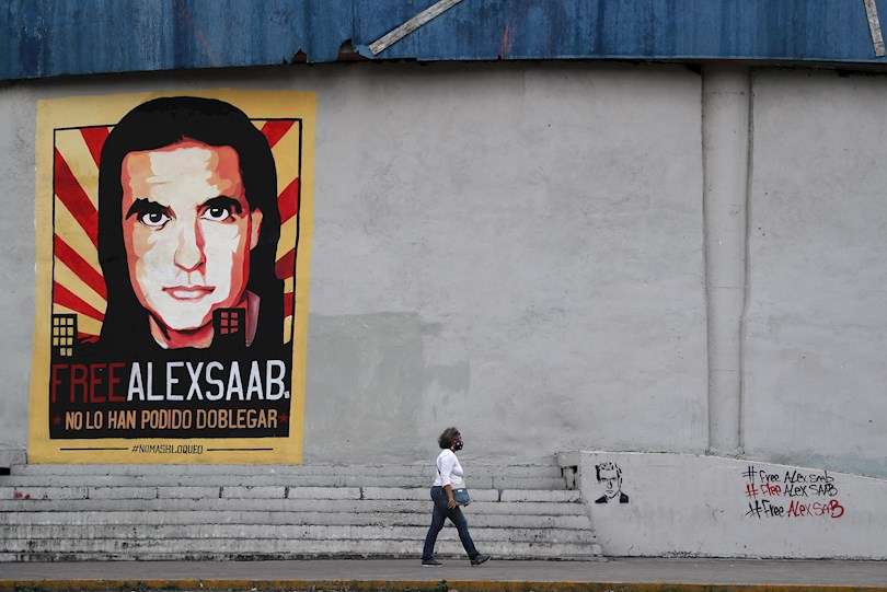Una mujer pasa frente a un cartel y mensajes de apoyo al empresario colombo-venezolano Alex Saab en Caracas (Venezuela), en una fotografía de archivo. EFE