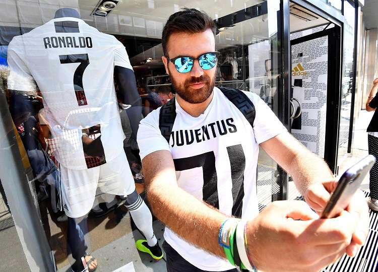 - Un aficionado del Juventus posa con la nueva camiseta &quot;bianconera&quot; que lucirá el delantero portugués. Foto: EFE