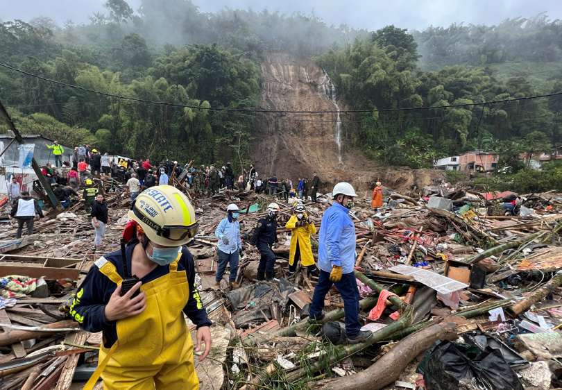 utoridades y miembros de cuerpos de rescate trabajan en una zona afectada por un deslizamiento de tierra causado por las fuertes lluvias que afectan la ciudad de Pereira.