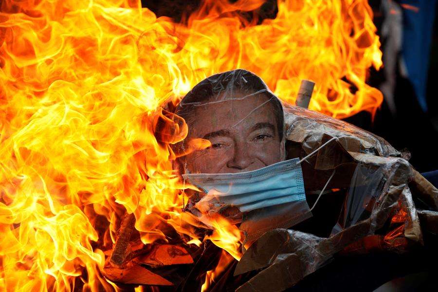 Un muñeco con la imagen del presidente de Panamá, Laurentino Cortizo es quemado durante una protesta 
