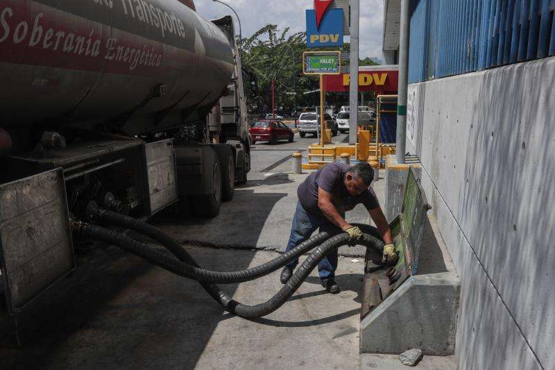 Un trabajador prepara las mangueras de un camión cisterna para llenar tanques de combustible, este viernes, en una estación de servicio de Caracas (Venezuela). EFE