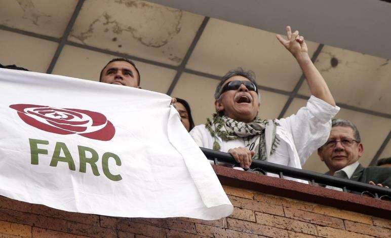 El líder del partido político FARC Seuxis Paucias Hernández (2d), alias &quot;Jesús Santrich&quot;, fue registrado este jueves en un balcón de la sede política del partido, luego de ser liberado por la Fiscalía colombiana, en Bogotá (Colombia). EFE