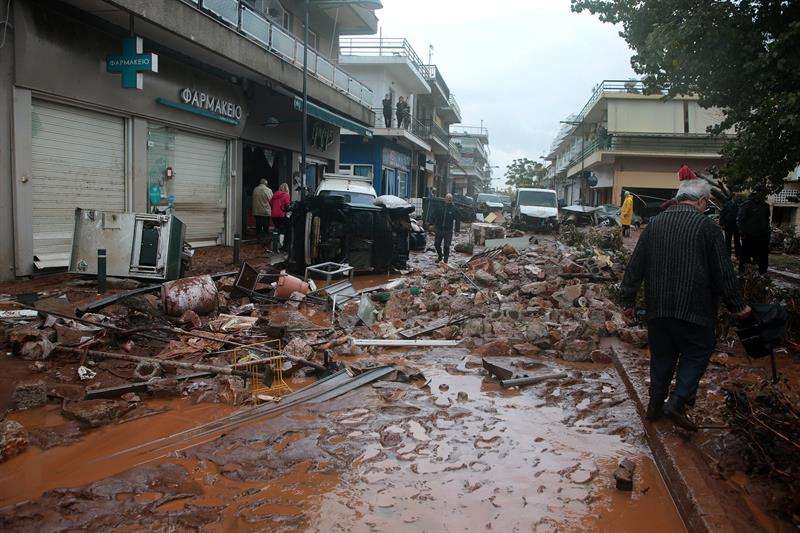 Residentes inspeccionan los destrozos causados por las inundaciones en el centro de Mandra (Grecia).  /  EFE