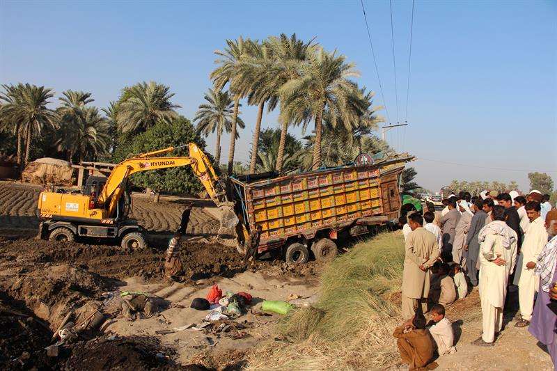 Varias personas observan el camión accidentado en Khairpur, Pakistán. / EFE