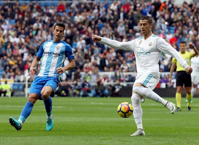 El delantero portugués del Real Madrid Cristiano Ronaldo (d) disputa un balón con el defensa del Málaga Luis Hernández (i) durante el partido correspondiente a la decimotercera jornada de LaLiga Santander/EFE