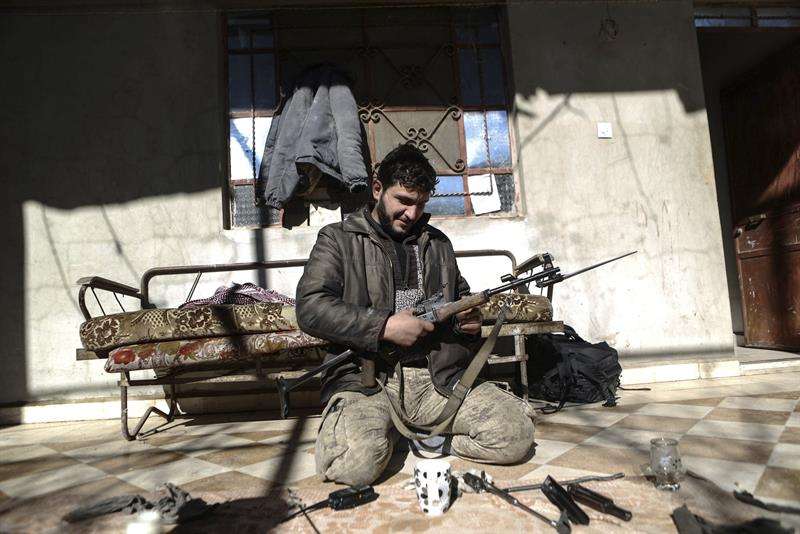 En la imagen, un soldado del Ejército del Islam (Jaysh al-Islam) limpiando su arma en la localidad de Duma, controlada por los rebeldes, a las afueras de Damasco, Siria. EFEArchivo
