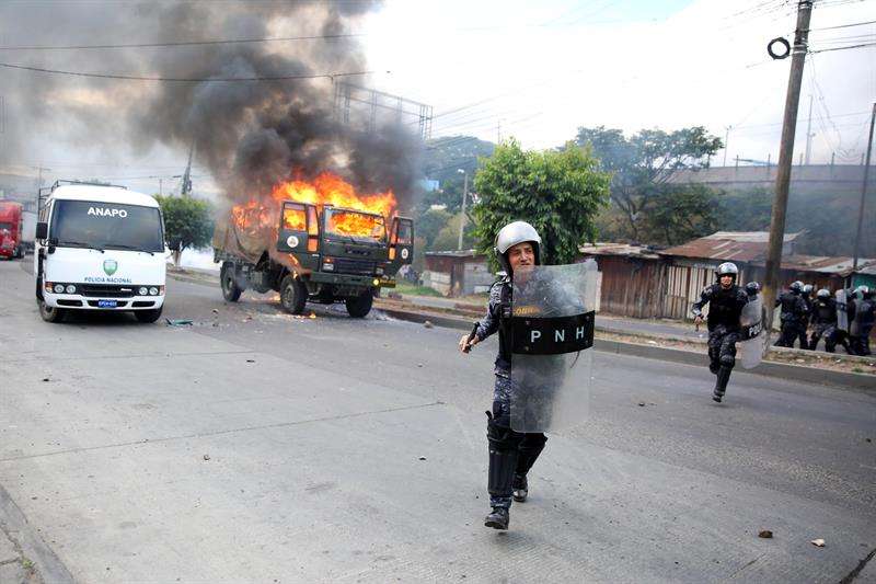 Decenas de policías hondureños se enfrentan con un grupo de manifestantes hoy, viernes 15 de diciembre de 2017, en Tegucigalpa (Honduras). EFE