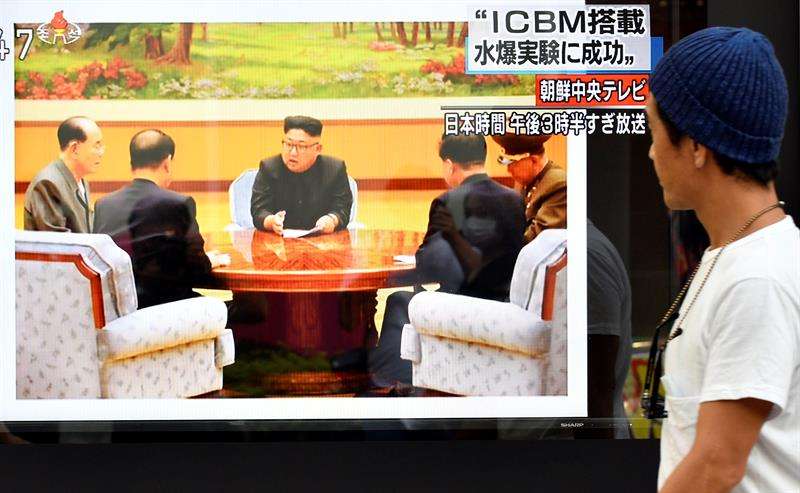Un peatón pasa delante de una televisión en la que aparece la imagen del líder de Corea del Norte, Kim Jong-un (C). EFEArchivo