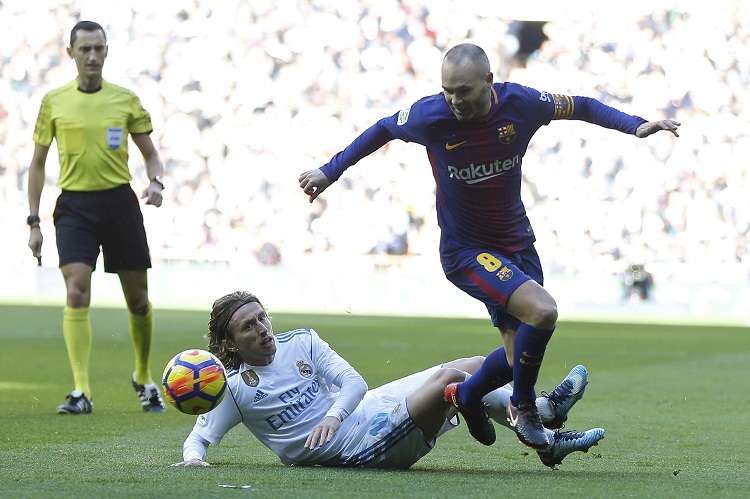 Luka Modric aborda a Andrés Iniesta de Barcelona (dcha.). Foto: AP