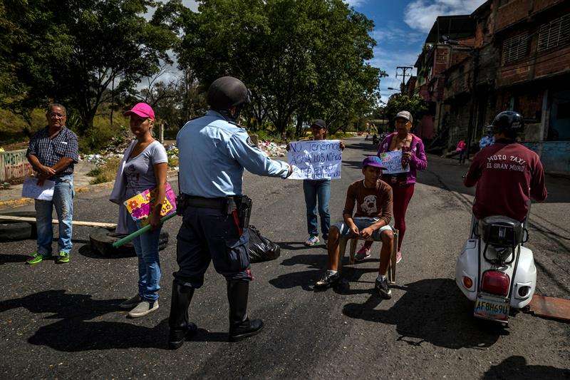 Un policía habla con un grupo de personas que participa en una manifestación hoy, miércoles 27 de diciembre del 2017, en Caracas (Venezuela). EFE