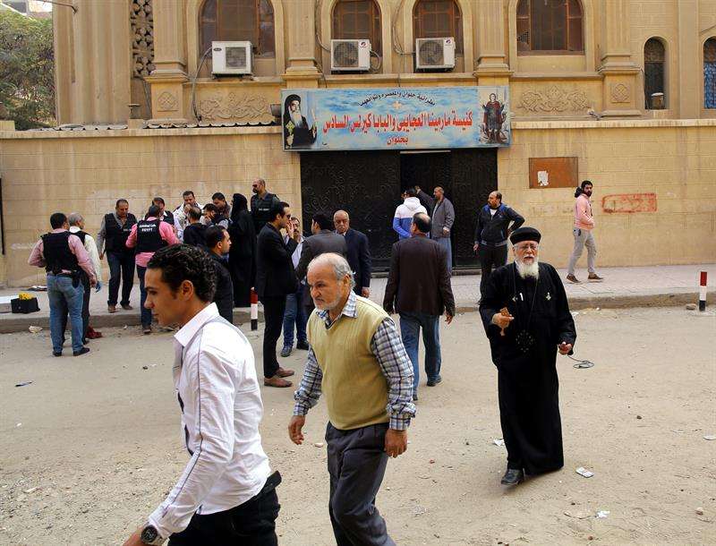 Un sacerdote y personal de seguridad permanecen a las puertas de la iglesia Mar Mina tras el ataque contra el templo en el distrito de Heluán, en el sureste de El Cairo (Egipto) hoy, 29 de diciembre de 2017. EFE