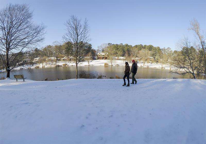 Dos personas caminan sobre la nieve después de la tormenta de nieve que azotó a Avondale Estates, en Atlanta, Georgia (Estados Unidos). / EFE