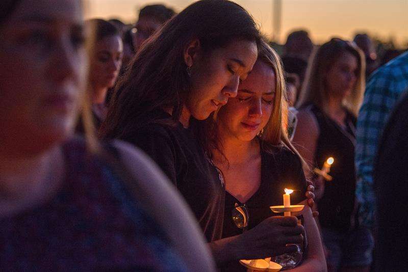Miles de personas participan en la vigila en recuerdo de las 17 víctimas mortales de la matanza perpetrada por Nikolas Cruz en la escuela secundaria Marjory Stoneman Douglas hoy, jueves 15 de febrero de 2018, en Pine Trails Park, Parkland. EFE