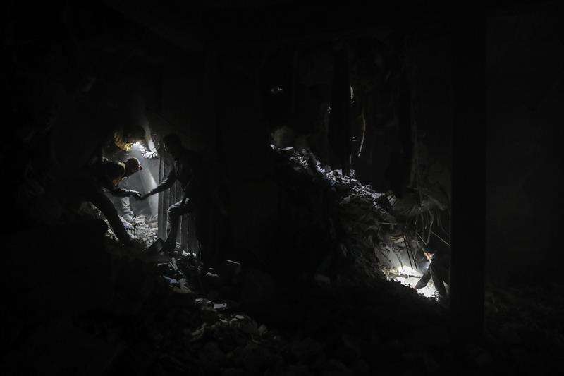 Voluntarios de los Cascos Blancos y civiles buscan supervivientes entre los escombros de un edificio bombardeado esta semana en la rebelde Duma, Guta Oriental (Siria). EFE