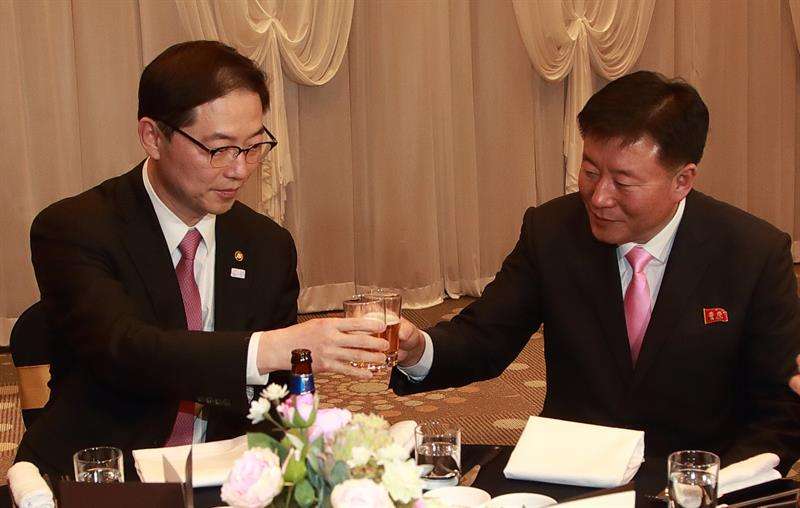 Chun Hae-sung (i), viceministro de unificación de Seúl, brinda con O Yong-chol (d), capitán del escuadrón de vítores de Corea del Norte, mientras organiza una cena banquete en Inje Speedium en Inje, provincia de Gangwon, Corea del Sur. EFE
