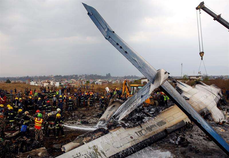 Miembros de los servicios de rescate buscan supervivientes entre los restos del avión que se estrelló en el aeropuerto de Katmandú (Nepal). EFE