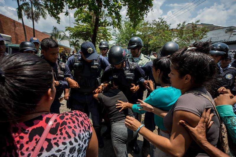Un grupo de familiares de presos fue registrado este miércoles al protestar ante miembros de la Policía, en las inmediaciones del centro de reclusión de la Policía Estatal de Carabobo (centro), en Valencia (Venezuela), donde se registró un motín. EFE
