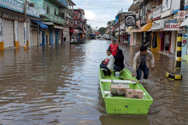 Habitantes de la ciudad de Minatitlán, en el estado de Veracruz(México), utilizan barcazas para cruzar las calles inundadas por las tormentas que afectan a buena parte de territorio mexicano, además de la llegada del huracán Willa. EFE
