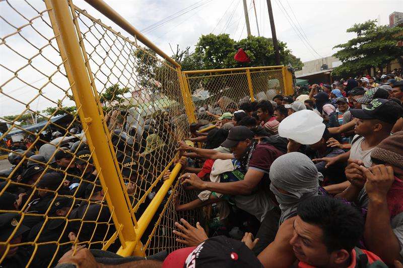 Cientos de migrantes centroamericanos que hacen parte de una segunda caravana rumbo a EE.UU intentan cruzar en el paso fronterizo entre México y Guatemala hoy, domingo 28 de octubre de 2018, en Tecún Umán (Guatemala). EFE