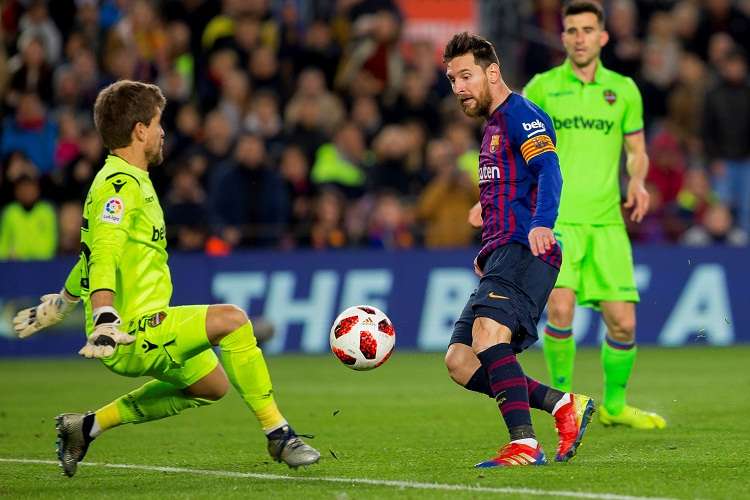 Leo Messi (centro), golpea el balón ante el guardameta del Levante, Aitor Fernández (izq.) Foto: EFE