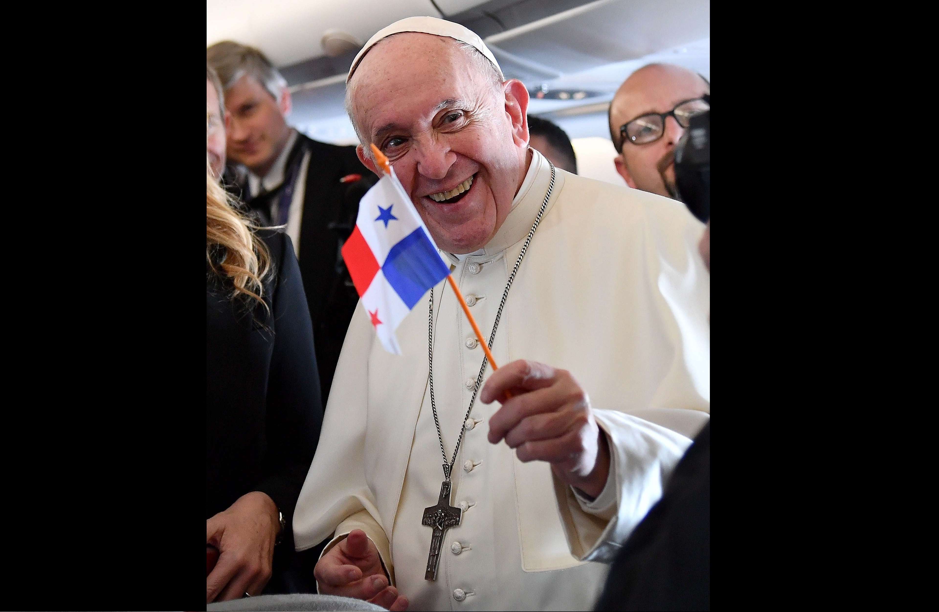 El papa Francisco (d) ondea una bandera panameña en el avión que le traslada este miércoles a Panamá. EFE
