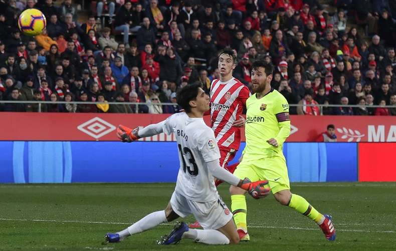 Messi toca el balón por el encima del arquero del Girona. / Foto AP